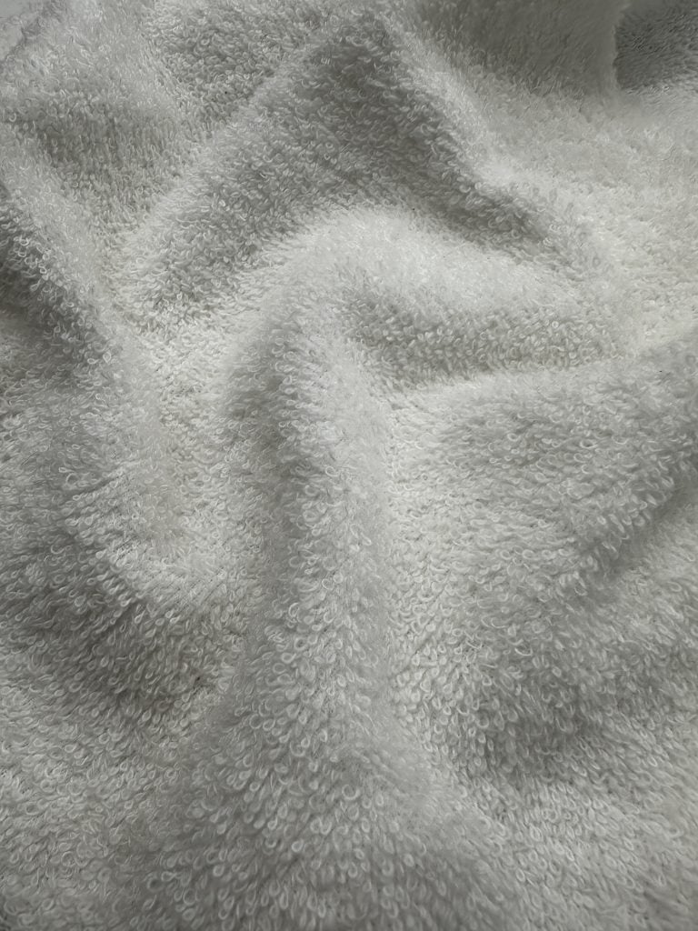 Soft white towel with plush, absorbent texture ideal for bath, spa, and wellness applications.