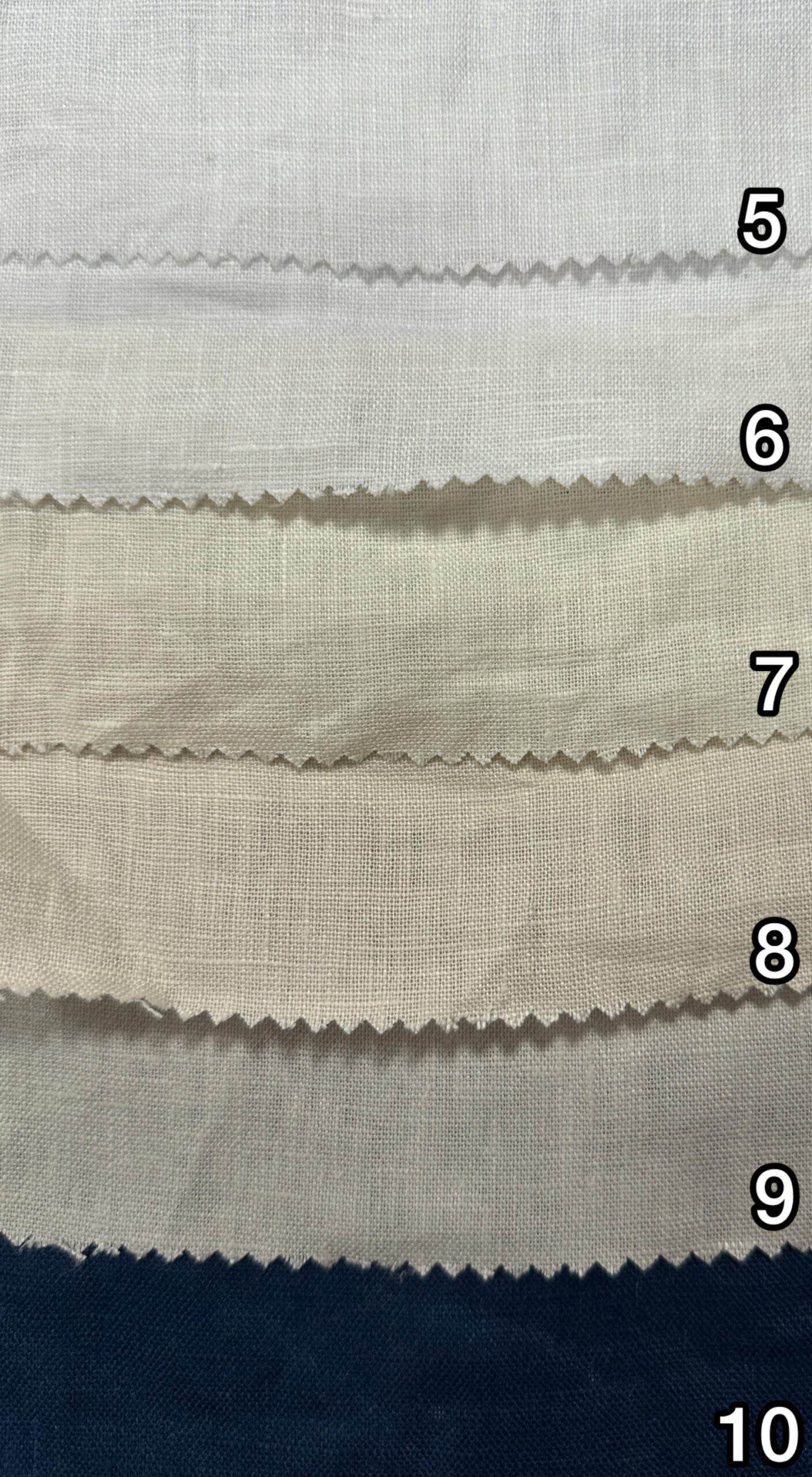 Close-up of pure linen fabric swatches in various shades and textures.
