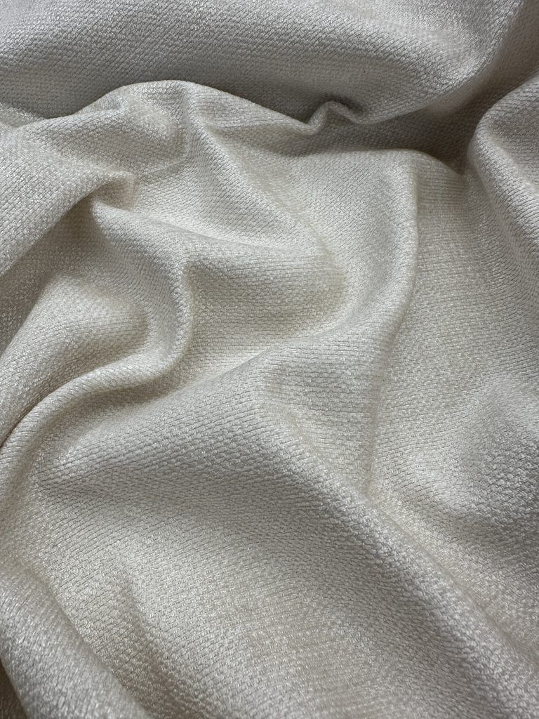 Elegant cream-colored fabric with a smooth texture, ideal for upholstery, drapery, and textile proje.