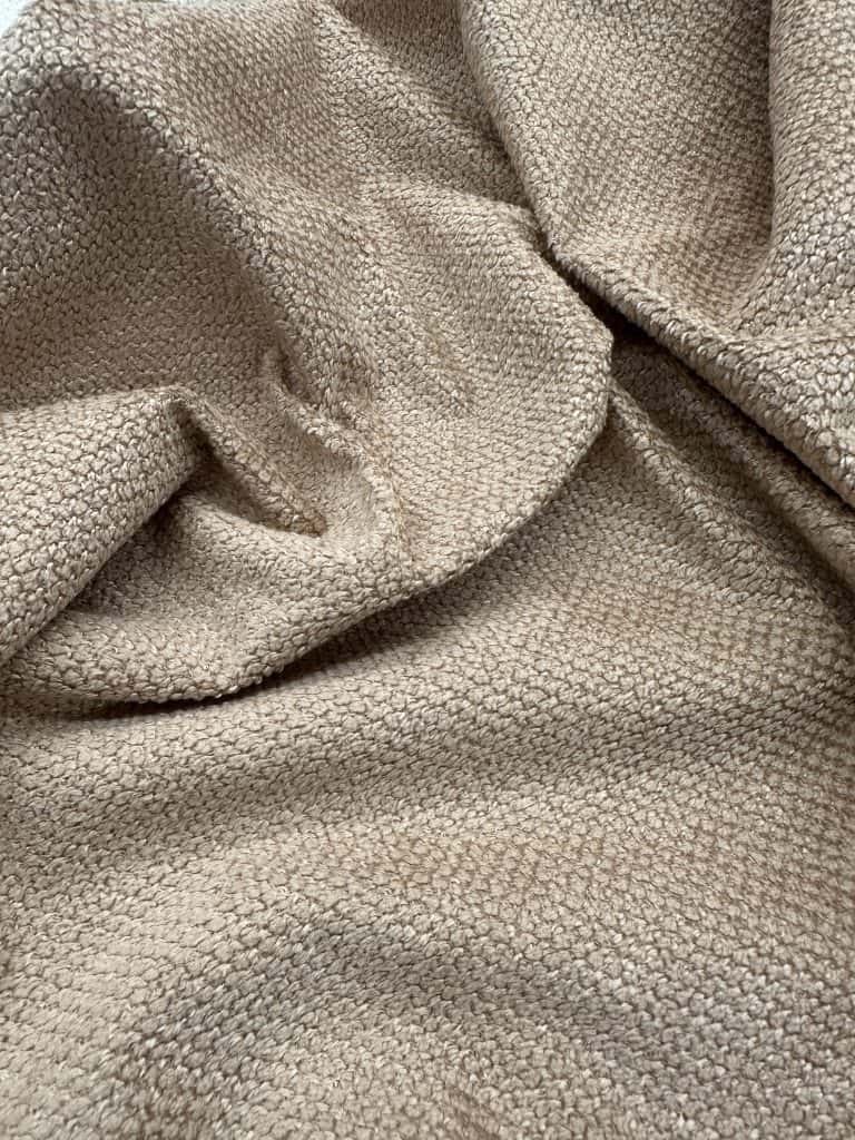 Beige textured fabric close-up, ideal for upholstery, fashion, and interior design projects. High-qu.