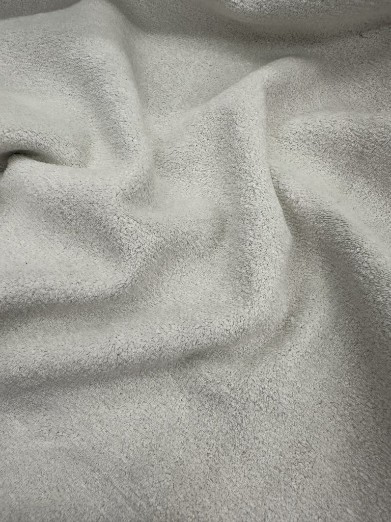Soft beige fabric with a smooth, plush texture ideal for upholstery, curtains, and textile projects.