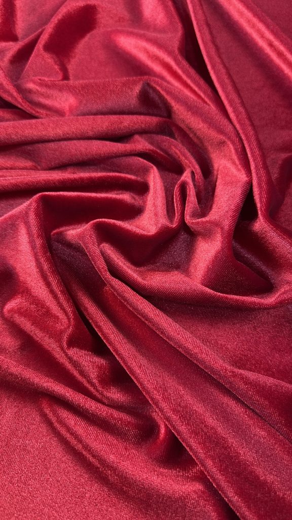 Red velvet spandex fabric with smooth, luxurious texture and vibrant color.