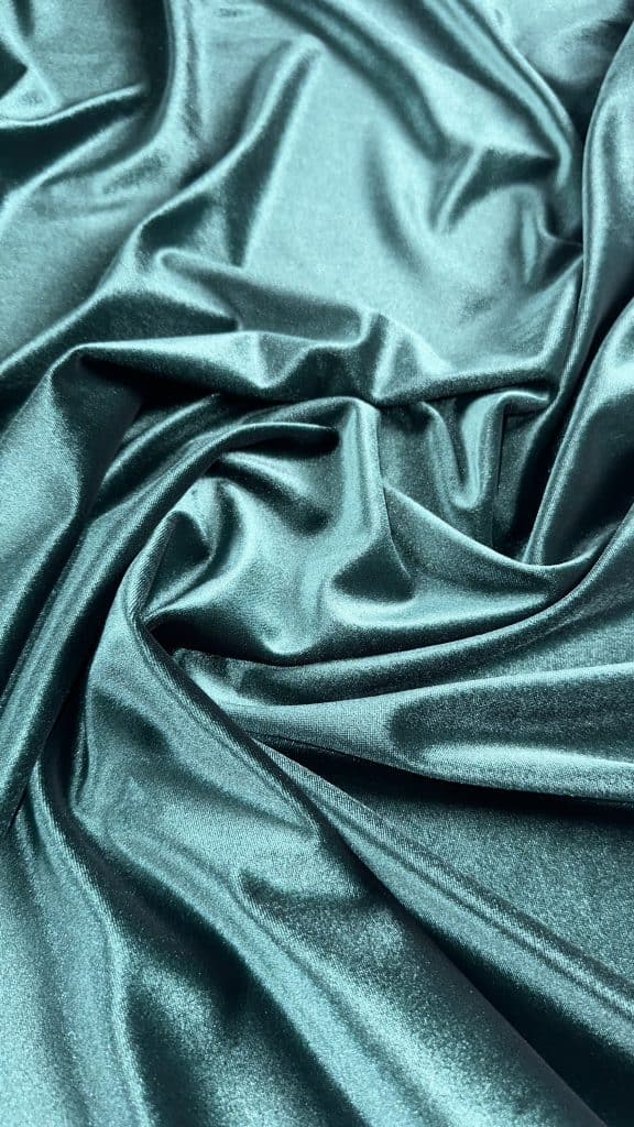 Luxurious teal velvet spandex heavyweight fabric for upholstery and fashion.