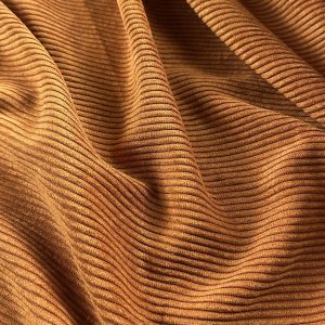 Close-up of brown corduroy fabric with fine ridges and soft texture.